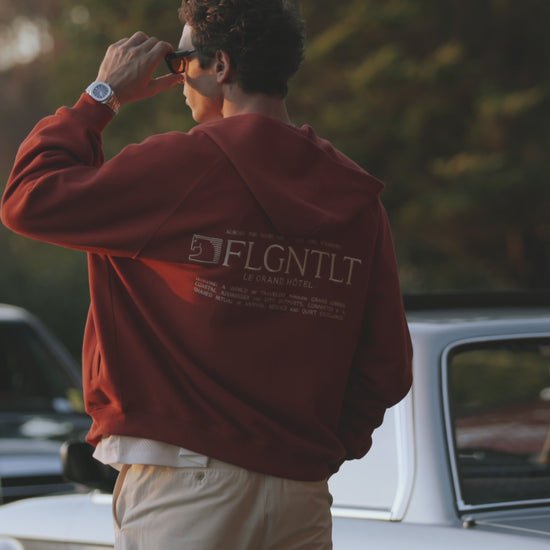 LE HÔTEL ZIP HOODIE in Terrakotta, getragen — Rückenansicht mit LE GRAND HÔTEL Print