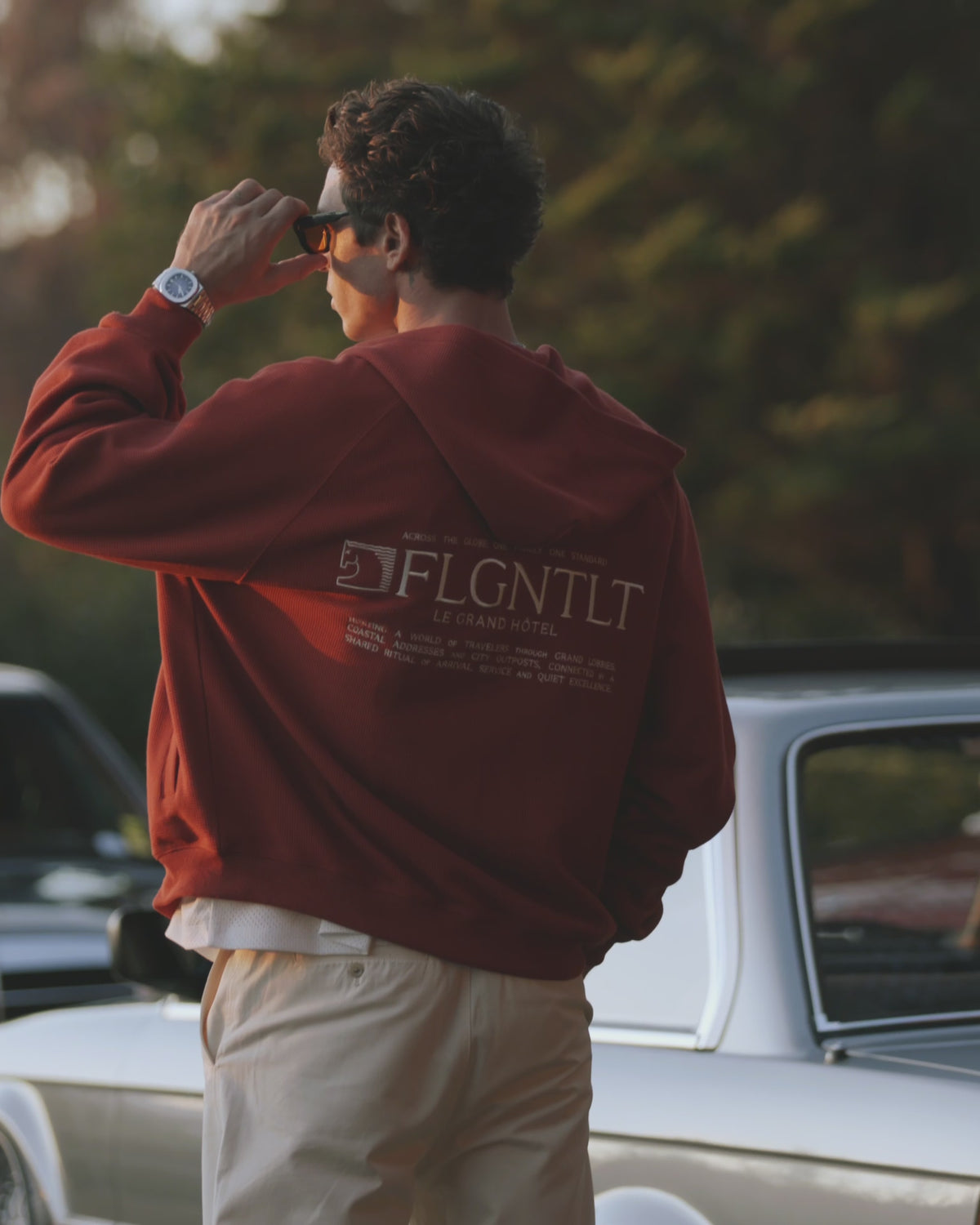 LE HÔTEL ZIP HOODIE in Terrakotta, getragen — Rückenansicht mit LE GRAND HÔTEL Print