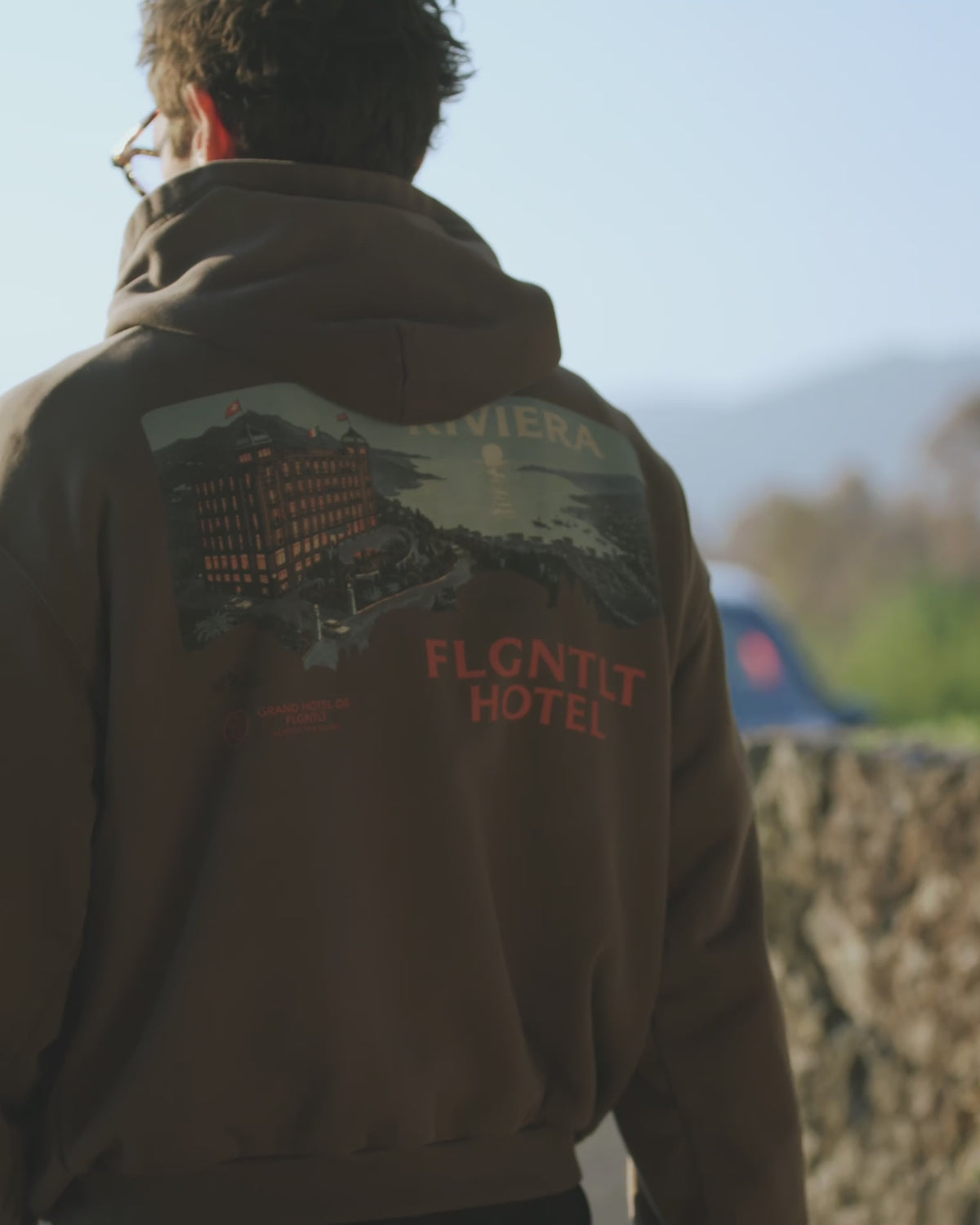 RIVIERA HOODIE in Braun, getragen — Rückenansicht mit RIVIERA HOTEL Print