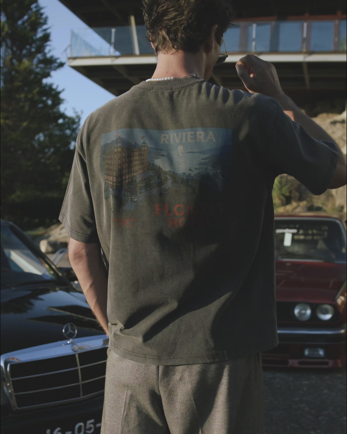 RIVIERA T-SHIRT in Oliv, getragen — Rückenansicht mit RIVIERA HOTEL Print